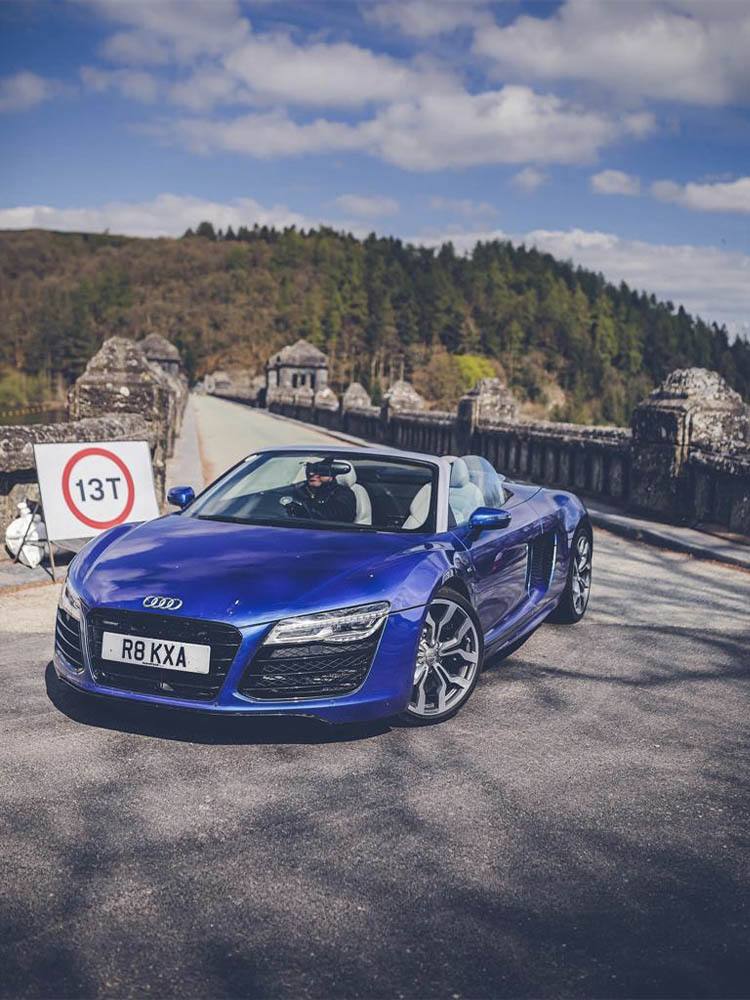 Blue Audi driving across a bridge